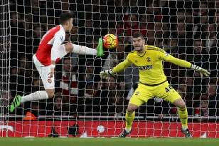 Penjaga gawang Southampton, Fraser Forster, berhadapan satu lawan satu dengan gelandang Arsenal, Mesut Oezil, saat kedua tim bertanding pada lanjutan Premier League di Stadion Emirates, Selasa (2/2/2016).