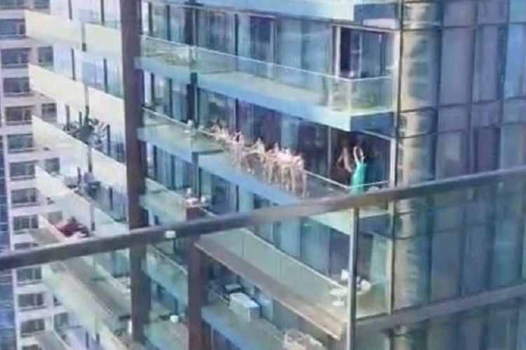 Sekelompok perempuan berpose telanjang di sebuah balkon gedung di Dubai, Uni Emirat Arab. Para perempuan itu ditangkap dan dijerat dengan berpesta secara tidak senonoh.