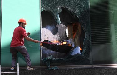 Petugas memecahkan kaca saat  berusaha memadamkan  kebakaran yang terjadi di Gedung Cyber I, Mampang, Jakarta, Kamis (2/12/2021). Dinas Penanggulangan Kebakaran dan Penyelamatan Jakarta mengerahkan 100 personel beserta 22 unit mobil pemadam ke lokasi. Api berhasil dipadamkan dalam waktu 30 menit.