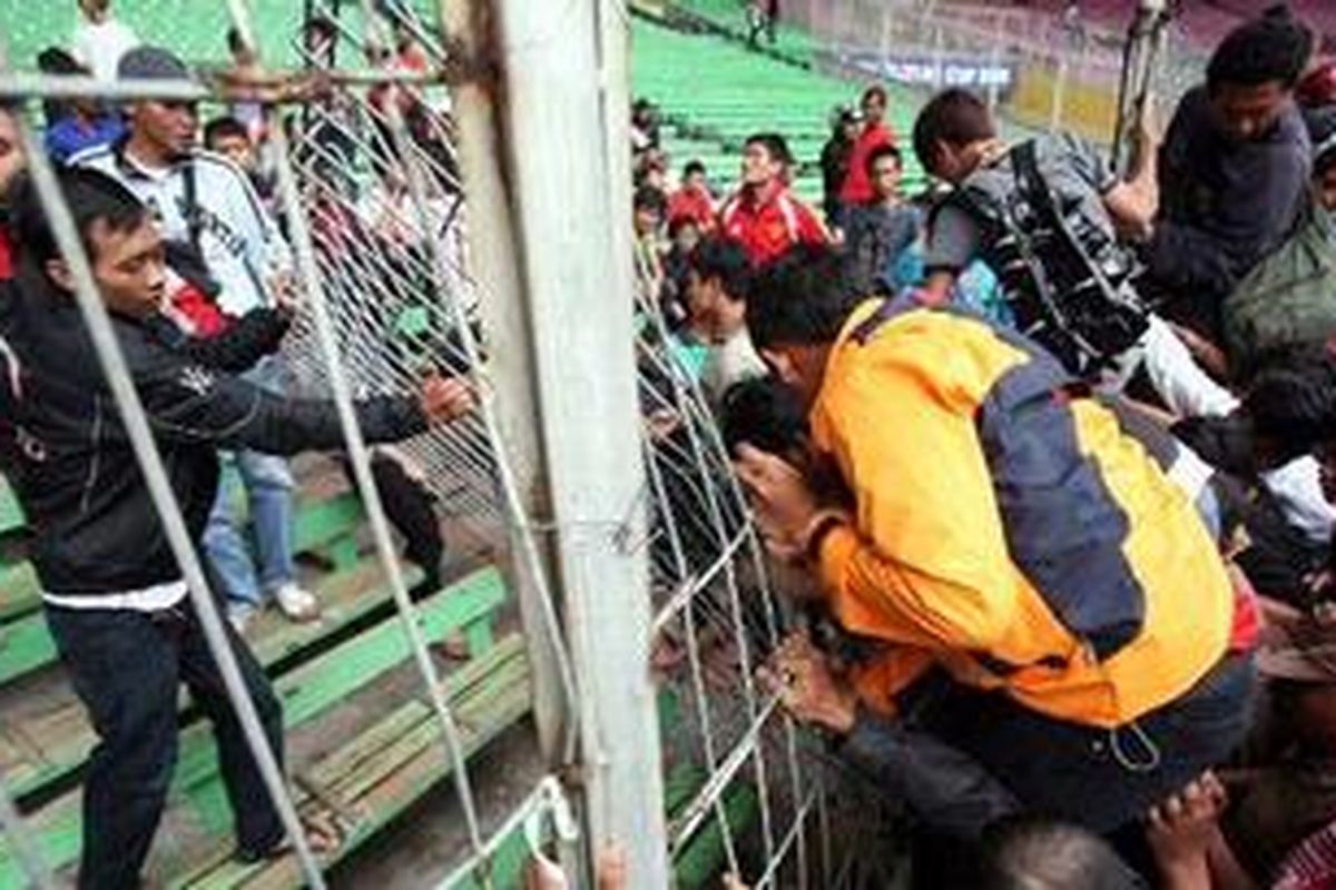 Massa yang emosi berebut masuk ke tribun ketika antre membeli tiket final Piala AFF di Gelora Bung Karno, Jakarta, Minggu (26/12/2010). 