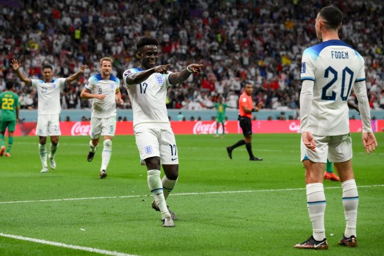 Winger timnas Inggris Bukayo Saka (tengah) merayakan golnya ke gawang Senegal bersama Phil Foden pada laga babak 16 besar Piala Dunia 2022 di Stadion Al Bayt, Al Khor, Qatar, Senin (5/12/2022) dini hari WIB. Inggris mampu mengakhiri laga kontra Senegal dengan skor 3-0. Selanjutnya, mereka akan melawan Perancis pada perempat final Piala Dunia 2022.