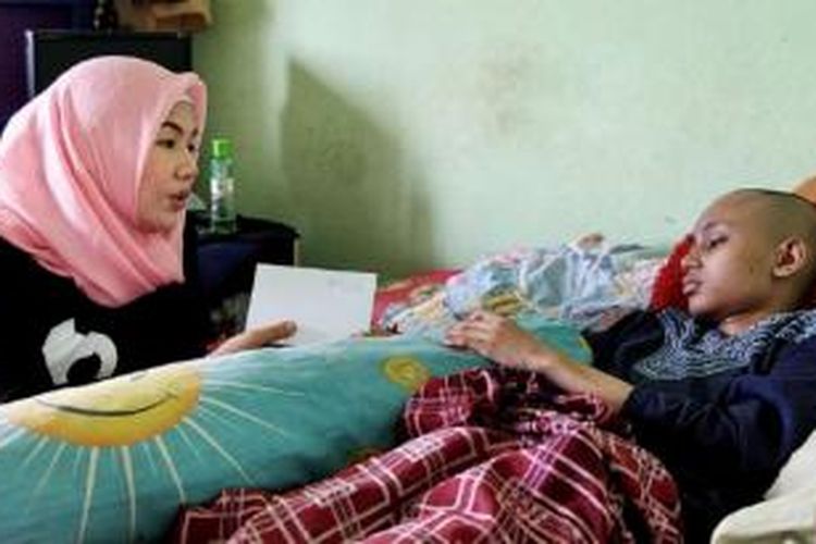 Yani (kiri) dari Komunitas Taufan berkeliling mengunjungi kediaman pasien antara lain kediaman Amar, di Rusun Bekasi, Jawa Barat, sabtu (12/9). Mereka berkunjung untuk memberi bantuan dan semangat kepada pasien. 
