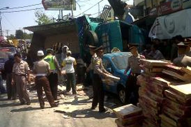 Warga dan polisi berusaha memindahkan muatan untuk mengevakuasi korban yang tertimpa truk di Jrakah, Kota Semarang, Senin (22/7/2013).