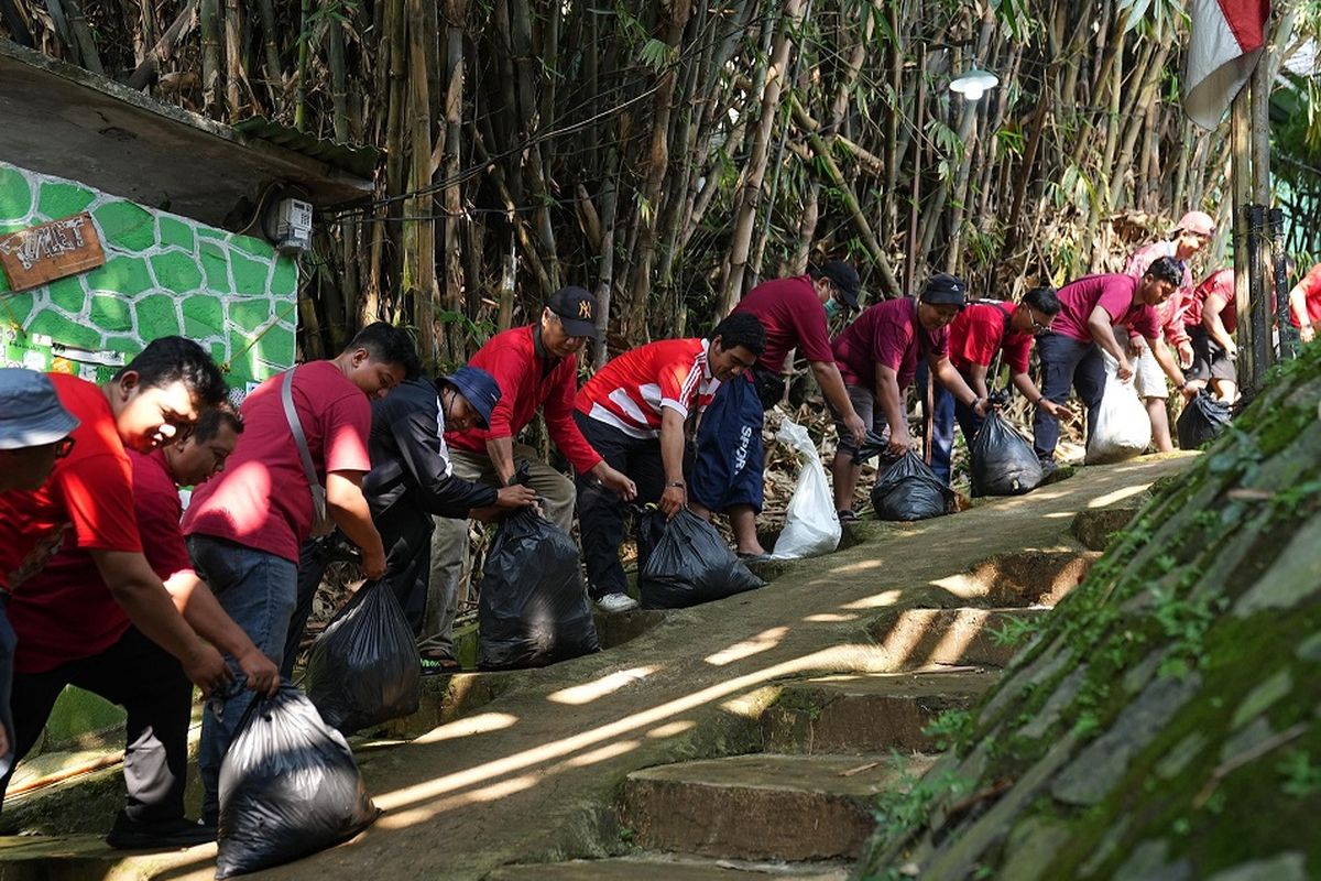 Karyawan CIMB Niaga membersihan sampah di Sungai Ciliwung, Sabtu (12/7/2025). 