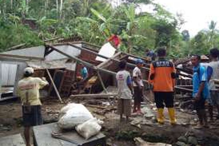 Foto : Warga sementara bersama tim BPBD Pacitan gotong royong membersihkan dan mengamankan reruntuhan bangunan rumah warga Desa Sempu, Kecamatan Nawangan, Kabupaten Pacitan yang roboh diterjang longsor