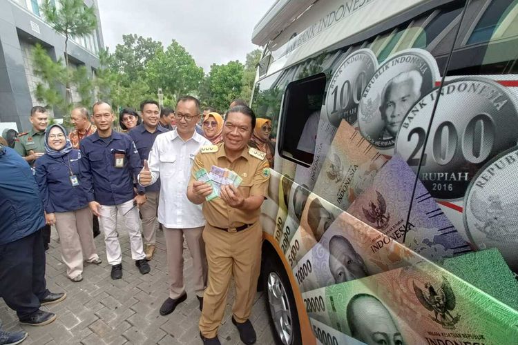 Penjabat Gubernur Banten Al Muktabar didampingi Kepala BI Banten Ameriza Moesa saat menukarkan uang pecahan baru di mobil kas keliling di Kantor BI Banten, Serang. Selasa (19/3/2024).