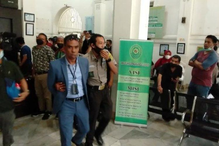 Seorang laki-laki yang dibawa ke luar Pengadilan Negeri Makassar karena membuat keributan saat sidang putusan kasus Nurdin Abdullah.