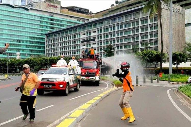 Penyemprotan disinfektan di Bundaran Hotel Indonesia atau Bundaran HI, Jalan MH Thamrin hingga Jalan Sudirman, Minggu (22/3/2020) pagi.