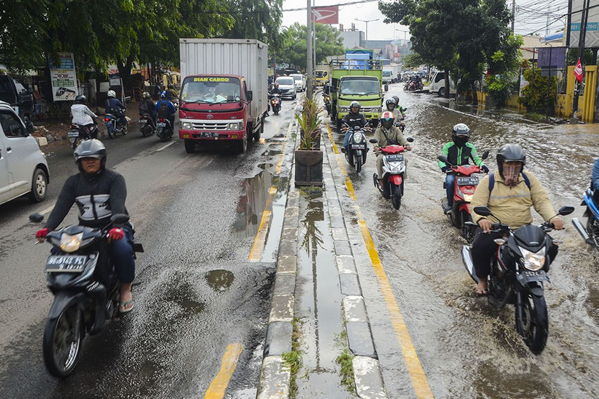 Sejumlah pengendara motor melintasi jalan Sultan Agung yang diberlakukan sistem contraflow akibat banjir di Bekasi, Jawa Barat, Selasa (21/1/2020). Banjir setinggi 20 cm diakibatkan oleh saluran drainase yang buruk sehingga menyebabkan kemacetan di sejumlah jalan raya Bekasi.