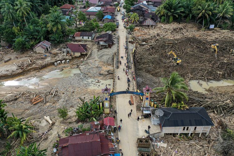 Foto udara sejumlah warga melintasi jembatan Aek Garoga 2 di Desa Aek Garoga, Kabupaten Tapanuli Tengah, Sumatera Utara, Kamis (11/12/2025). KLH memeriksa delapan perusahaan di DAS Batang Toru yang diduga melanggar aturan lingkungan dan memperparah banjir bandang Sumatera Utara.