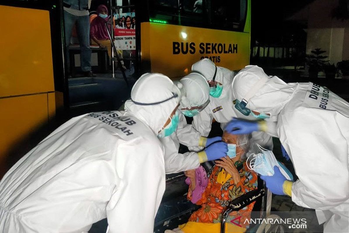 Petugas medis dan Unit Pelaksana Angkutan Sekolah (UPAS) Dishub DKI Jakarta mengevakuasi pasien manula terkonfirmasi COVID-19 dari panti di kawasan Cengkareng, Jakarta Barat, menuju RSKD Duren Sawit, Jakarta Timur, Selasa (22/12/2020) dini hari.