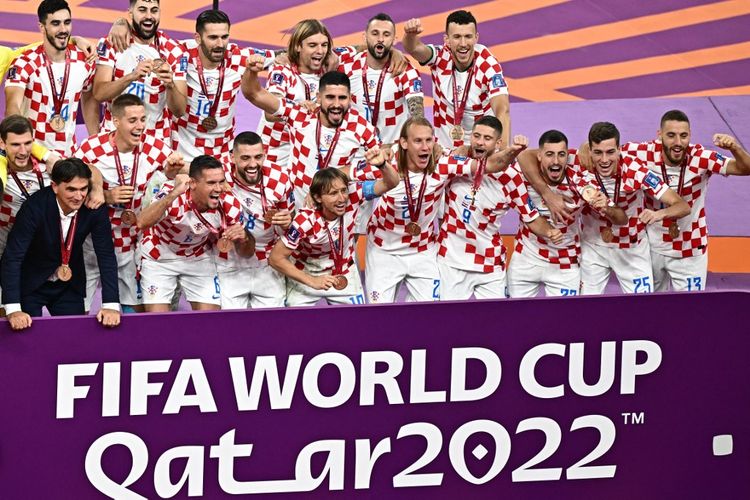 Pemain-pemain Kroasia melakukan selebrasi usai dipastikan menyabet status sebagai peringkat ketiga Piala Dunia 2022. Peringkat ketiga Piala Dunia 2022 diamankan Kroasia usai mengalahkan Maroko 2-1 di Stadion Internasional Khalifa, Sabtu 17 Desember 2022. (Photo by Anne-Christine POUJOULAT / AFP)