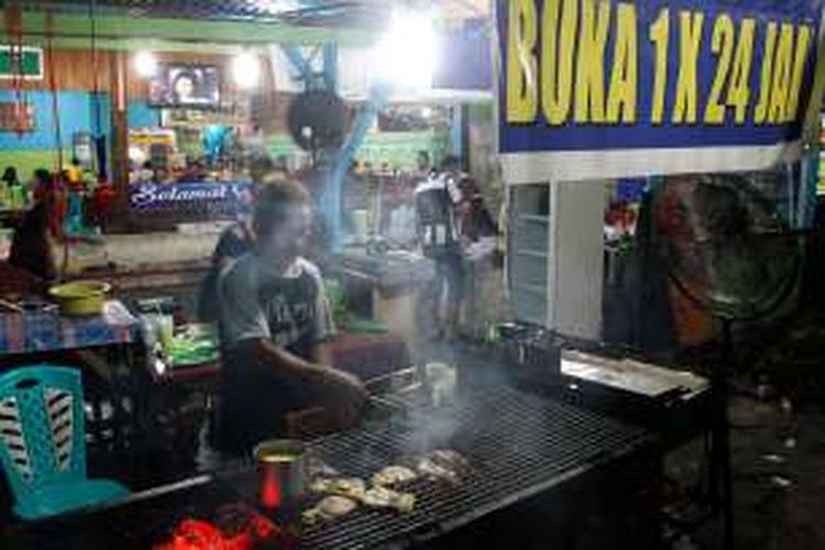 Petugas di Rumah Makan Ikan Bakar Aikana di Pasar Bersehati Calaca, Manado, Sumatera Utara, sedang membakar daging ikan tuna pesanan pelanggan mereka.