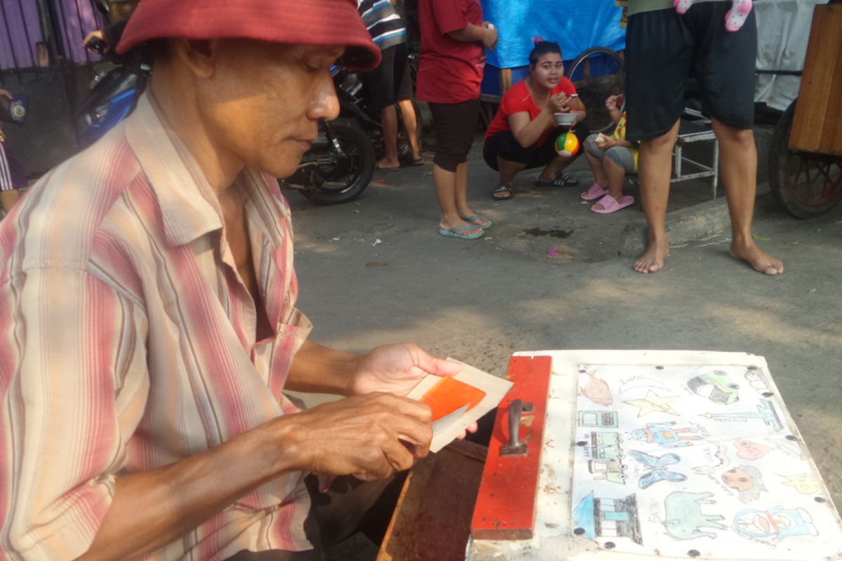 Dadang, penjual agar-agar di kawasan Senen, Jakarta Pusat. Untuk menarik minta pembeli khususnya anak-anak, Dadang membentuk agar-agar menyerupai gambar kartun, hingga sejumlah bentuk gambar lainnya, Minggu (9/7/2017)