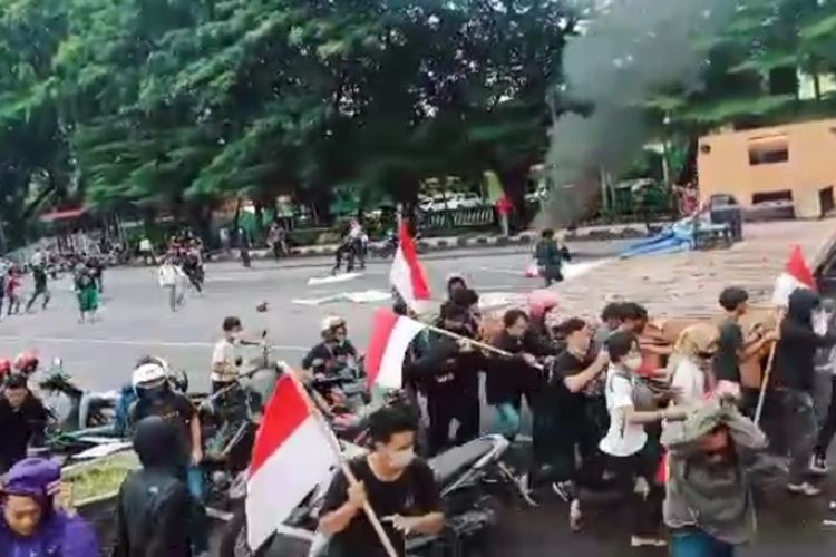 Massa aksi tolak kedatangan Rizieq Shihab saat diserang oleh sekelompok orang tak dikenal di Jalan Jenderal Sudirman, Makassar, Selasa (1/12/2020).