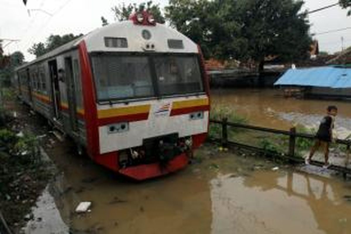 Kereta rel listrik (KRL) yang hendak melintas di Bukit Duri, Jakarta Selatan, terpaksa berhenti karena banjir hingga setinggi satu meter, Senin (13/1/2014). Sejumlah wilayah di Jakarta terendam banjir akibat curah hujan yang tinggi dan air kiriman dari Bogor. TRIBUNNEWS/HERUDIN