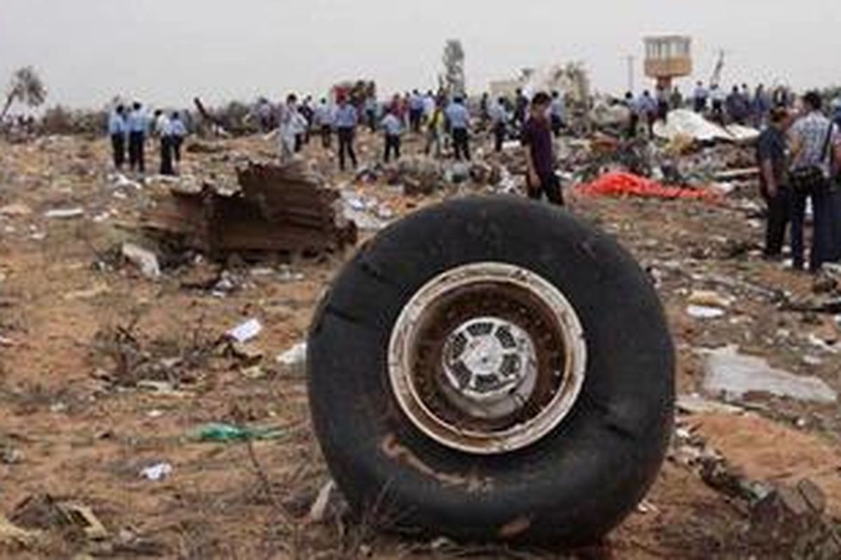 Petugas keamanan dan tim penyelamat berada di antara puing pesawat Airbus A330 milik maskapai penerbangan Afriqiyah Airways yang jatuh di Bandara Tripoli, Rabu (12/5/2010). Sebanyak 105 orang dilaporkan tewas dan seorang bocah delapan tahun selamat.