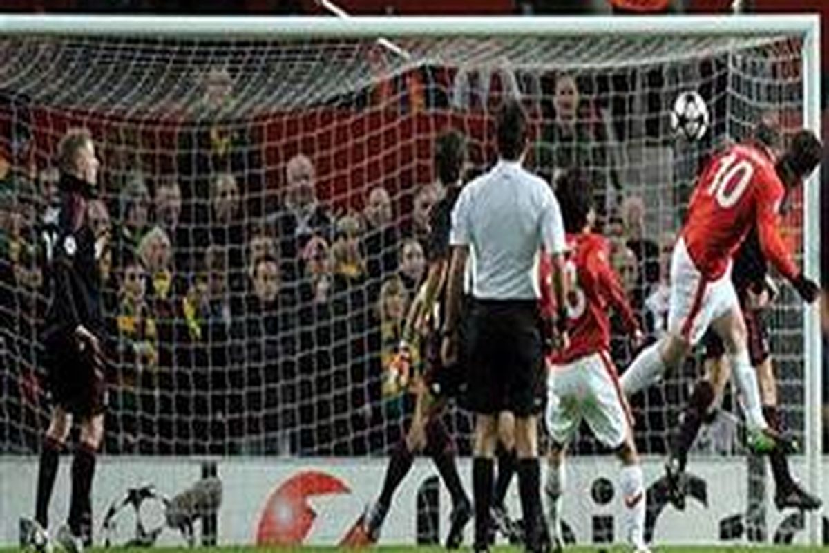 Penyerang Manchester United, Wayne Rooney (kanan) menanduk bola masuk ke gawang AC Milan, pada laga leg kedua 16 besar Liga Champions, di Old Trafford, Rabu (10/3/2010).