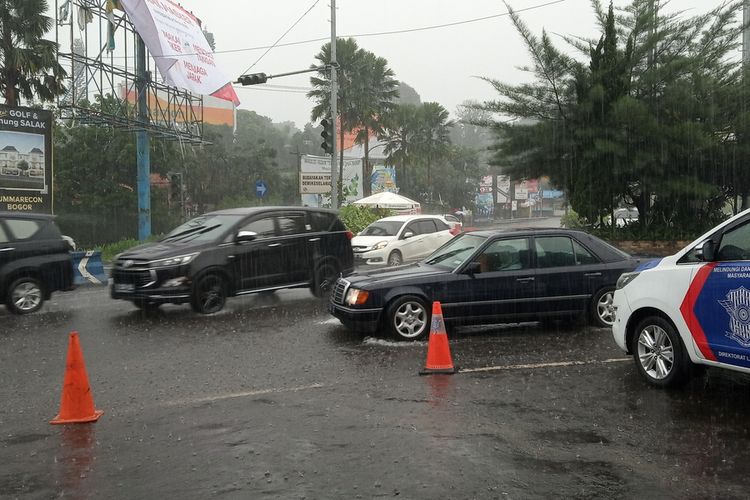 Anggota Satlantas Polres Bogor sedang mengatur arus lalu lintas di Jalan Raya Bogor, Simpang Gadog, Ciawi, Puncak Bogor, Jawa Barat, Sabtu (31/10/2020).