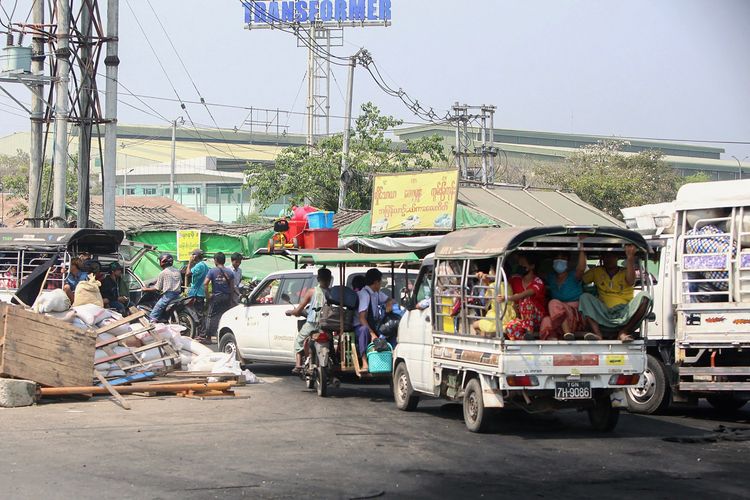 Orang-orang mengungsi dengan mobil pikap dan truk di kotapraja Hlaing Tharyar, Yangon, pada Selasa (16/3/2021), saat wilayah mereka digeruduk militer Myanmar.