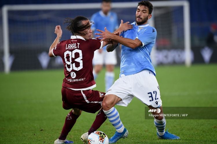 Torinos midfielder Uruguayan Diego Laxalt (L) fights for the ball with Lazios Italian midfielder Danilo Cataldi during the Italian Serie A football match between Lazio and Torino on October 30, 2019 at the Olympic Stadium in Rome. (Photo by Filippo MONTEFORTE / AFP)