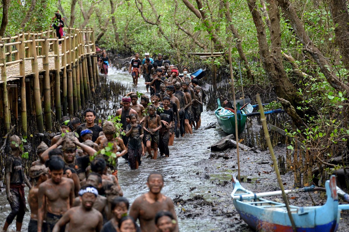 Sejumlah warga mengikuti tradisi Mebuug-Buugan atau mandi lumpur di Desa Kedonganan, Badung, Bali, Kamis (23/3/2023). Tradisi Mebuug-Buugan yang dilakukan setelah Hari Raya Nyepi tersebut dilakukan sebagai simbol menghilangkan kekotoran atau hal-hal negatif.