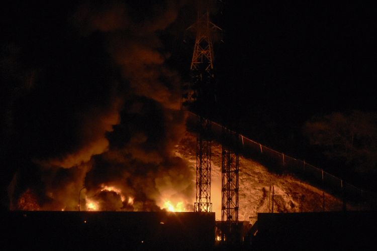 Api kebakaran di kompleks militer Fuerte Tiuna, setelah serangkaian ledakan mengguncang Caracas, Venezuela, Sabtu (3/1/2026). Amerika Serikat disebut telah memulai serangan darat di Venezuela.