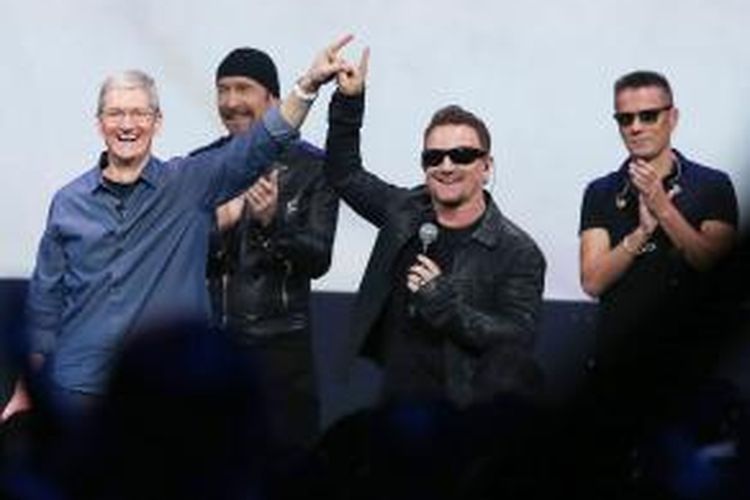 Para personel band rock Irlandia U2, yaitu Bono (kedua dari kanan), The Edge (kedua dari kiri), dan Larry Mullen Jr (paling kanan) berfoto bersama CEO Apple, Tim Cook (paling kiri), di Flint Center, Cupertino, California, AS, dalam acara peluncuran tiga produk terkini perusahaan tersebut, pada 9 September 2014 waktu setempat.