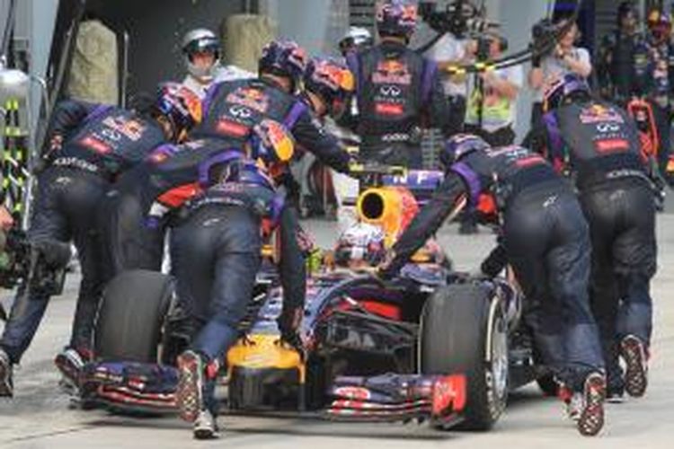 Kru Red Bull Racing mendorong mobil pebalap Australia Daniel Ricciardo kembali ke pit Sirkuit Sepang saat GP Malaysia, Minggu (30/3/2014).
