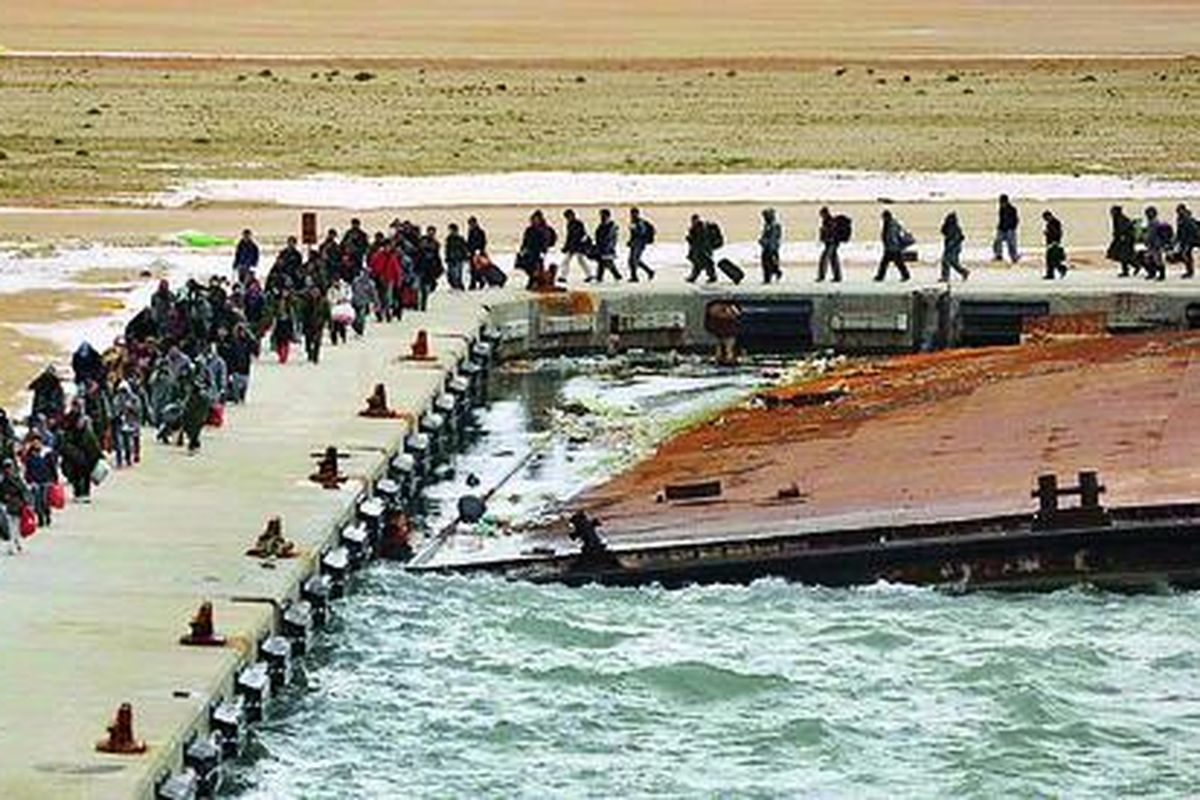 Salah satu foto yang dirilis kantor berita China, Xinhua, mempertunjukkan sejumlah warga China tengah menanti kapal Yunani yang dicarter Pemerintah China untuk mengevakuasi warga China di Libya, dari pelabuhan Benghazi, Libya, Jumat (25/2). 