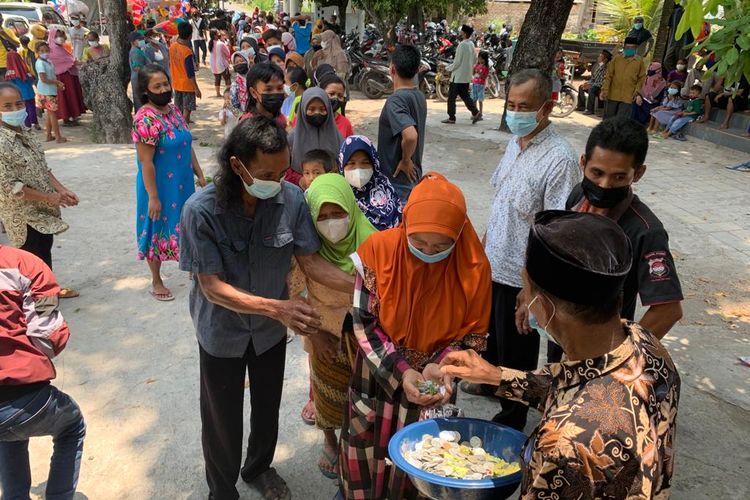 ANTRE—Warga Desa Kedondong, Kecamatan Kebonsari, Kabupaten Madiun, Jawa Timur mengantre mendapatkan uang koin dalam rangkaian peringatan Maulid Nabi Muhammad SAW yang digelar di halaman keluarga Ali Mutohar. Tradisi bagi uang koin berlangsung setiap tahunnya saat memperingati kelahiran Nabi Muhammad SAW. 