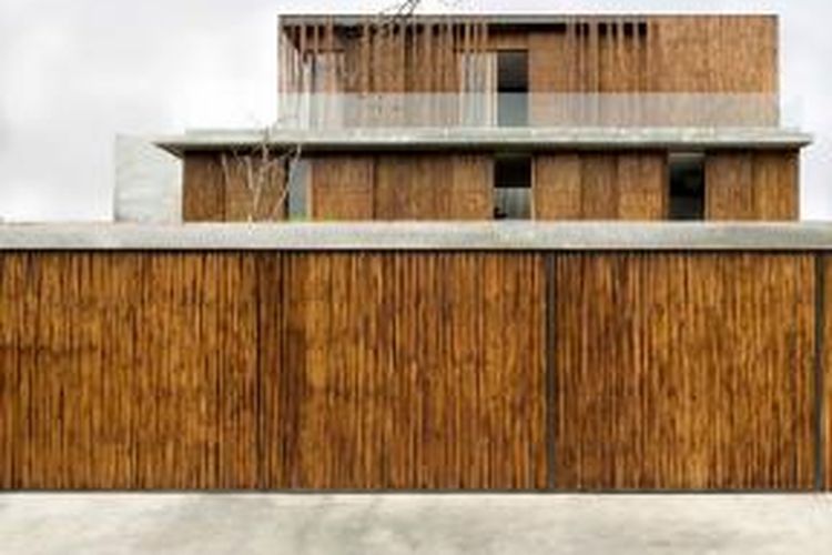 Fasad rumah ini sebagian besar dibangun dari bambu, begitu pula dengan pagarnya. 