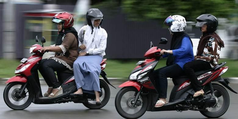 Orang yang dibonceng duduk menghadap ke samping dan ke depan.