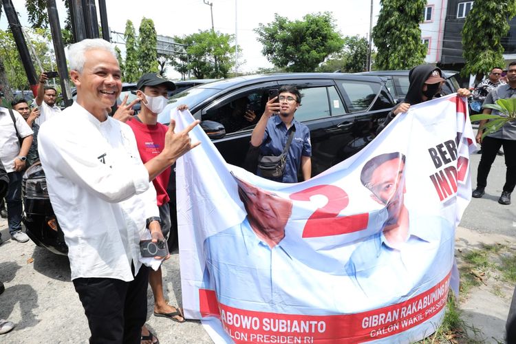 Calon presiden nomor urut 3 Ganjar Pranowo disambut spanduk bergambar pasangan calon presiden dan wakil presiden nomor urut 2, Prabowo Subianto-Gibran Rakabuming, di tengah kunjungan kampanyenya di Baliklapan, Selasa (6/2/2024).