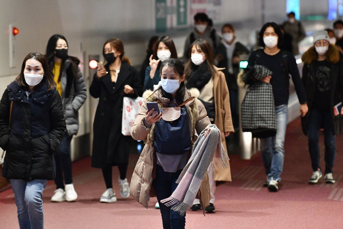 Penumpang dari luar negeri menggunakan masker untuk mencegah penyebaran virus Corona saat tiba di Bandara Internasional Haneda, 28 Januari 2020. 
