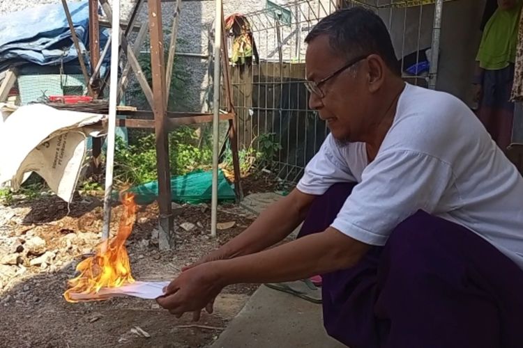 Seorang warga bernama Ramin (66) menyalakan api ke arah kertas yang sudah dicampur air sumur di Desa Pengasinan, Kabupaten Bogor, Jawa Barat, Jumat (8/9/2023).