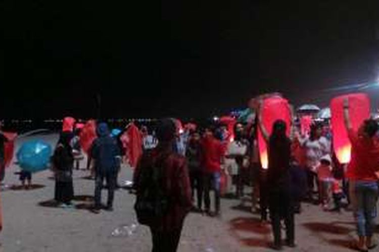 Wisatawan melepaskan lampion di tengah hujan rintik-rintik di Pantai Lagoon Taman Impian Jaya Ancol, Jakarta, Senin (8/2/2016) malam.