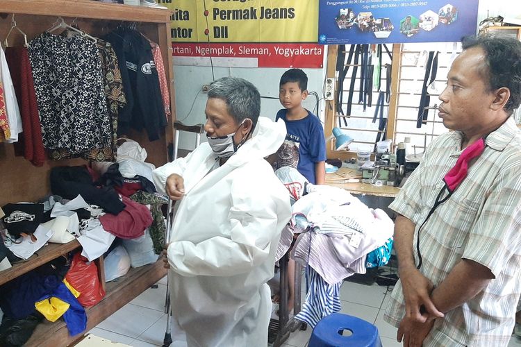 Salah satu penjahit difabel saat menunjukan contoh APD berupa pakaian khusus yang dipesan oleh rumah sakit