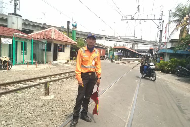 Sulaiman terlihat sedang mengawasi perlintasan kereta tanpa palang di Stasiun Ancol pada pukul 12.30 siang (04/12/2019)