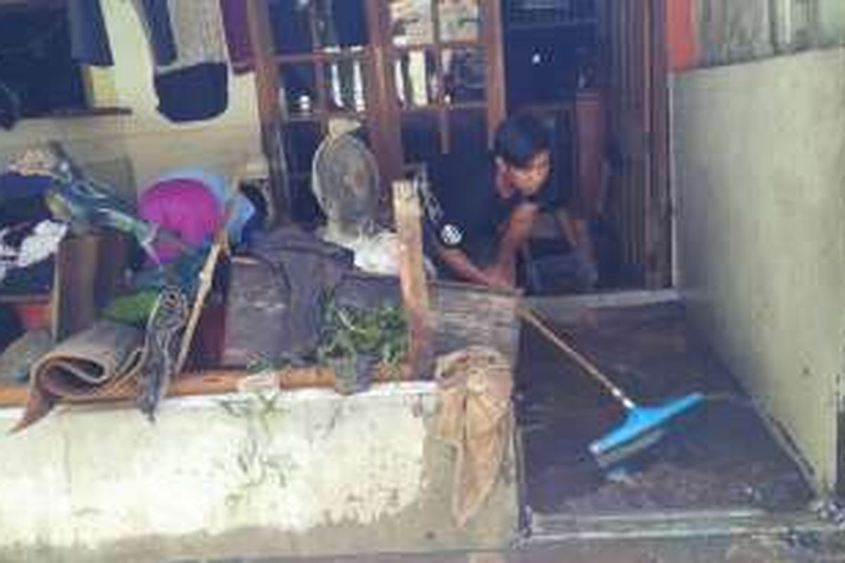 Warga di Kelurahan Pondok Labu, Cilandak, Jakarta Selatan, membersihkan rumahnya akibat banjir, Sabtu (20/8/2016).