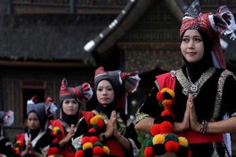 Perempuan menggunakan pakaian adat Sumatera Barat saat penyambutan tamu di garis finish etape tiga Tour de Singkarak 2013 di Istano Basa Pagaruyung, Nagari Pagaruyung, Kabupaten Tanah Datar, Sumatera Barat, Selasa (4/6/2013). 