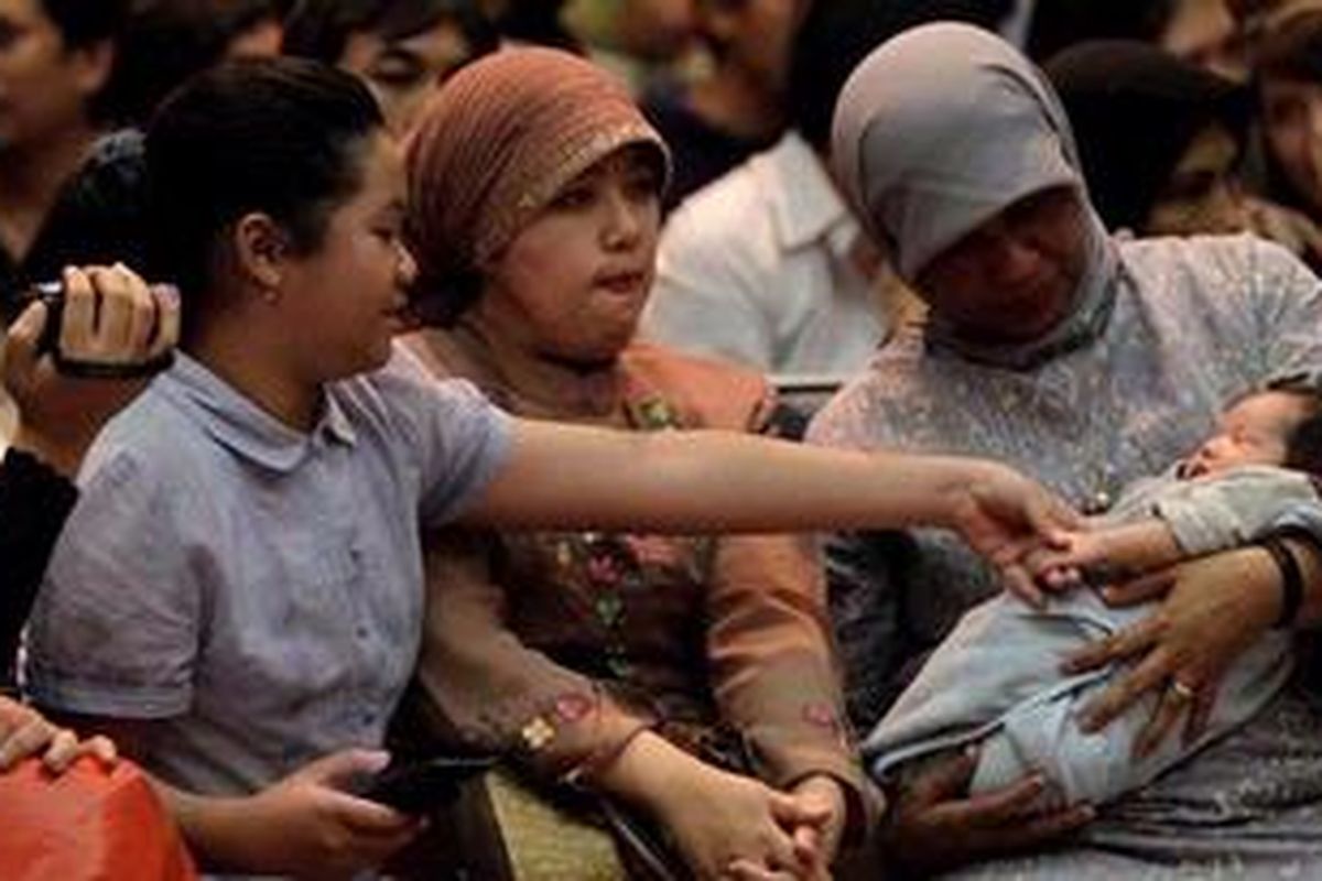 Keluarga dan warga negara Indonesia yang dievakuasi dari Jepang saat serah terima di Kementerian Luar Negeri, Jakarta, Selasa (15/3/2011). Sebanyak 99 warga negara Indonesia dievakuasi Kementerian Luar Negeri terkait dampak bencana gempa bumi, tsunami, dan ancaman radiasi nuklir akibat kerusakan pada pembangkit listrik tenaga nuklir di Fukushima. 