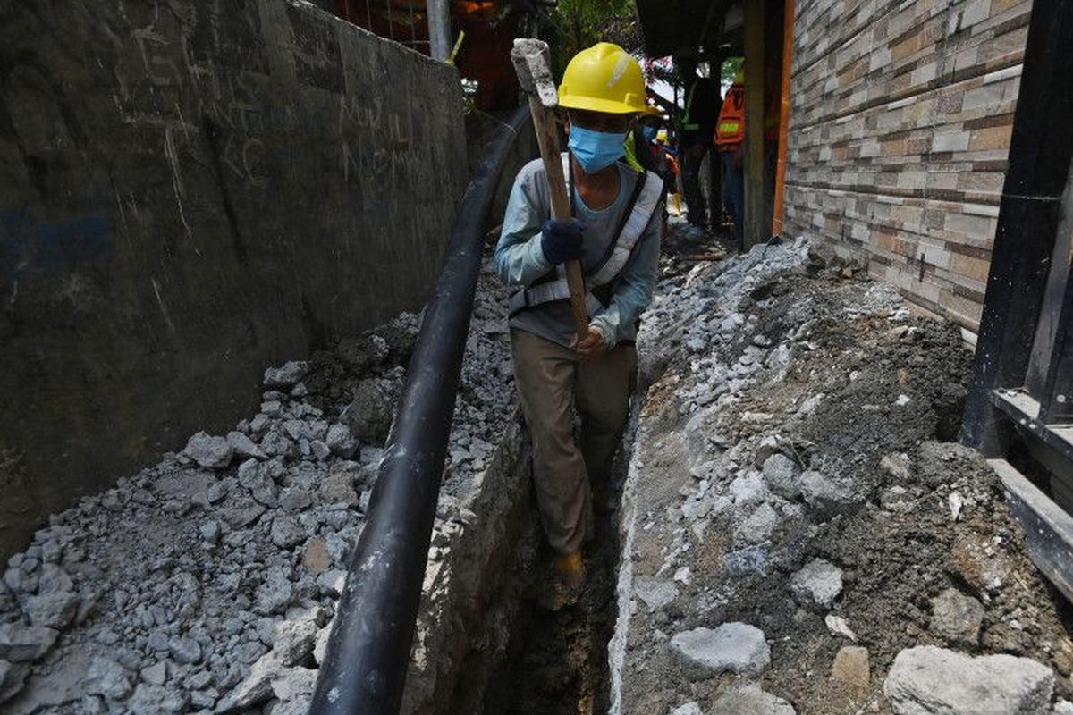 Pekerja Perumda Perusahaan Air Minum (PAM) Jaya menggali tanah untuk jaringan pipa air bersih di lingkungan RW 01, Kamal Muara, Jakarta, Selasa (23/8/2022). PAM Jaya menargetkan 100 persen warga DKI Jakarta dapat terlayani pipa air bersih pada 2030. 