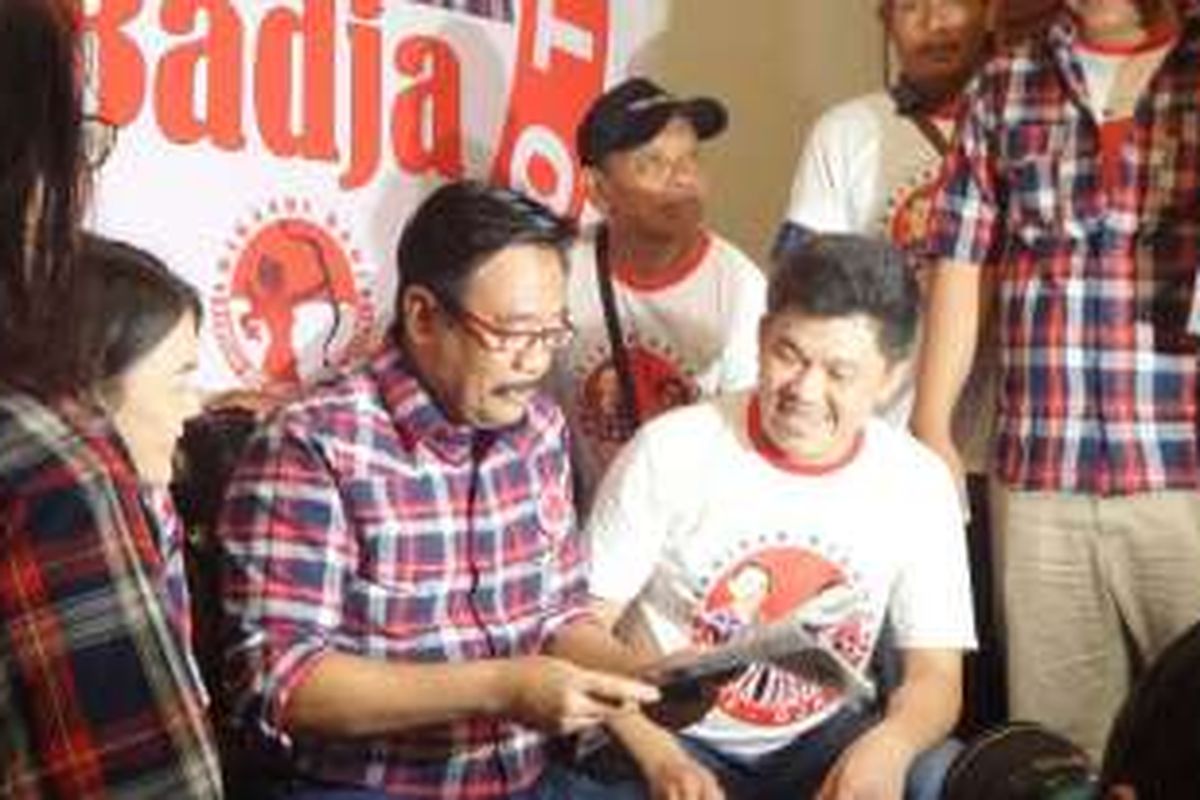 Bakal cawagub DKI Djarot Saiful Hidayat mencoba kacamata baca yang dibagikan relawan Barisan Relawan Basuki Djarot di Cipinang,Minggu (23/10/2016). 