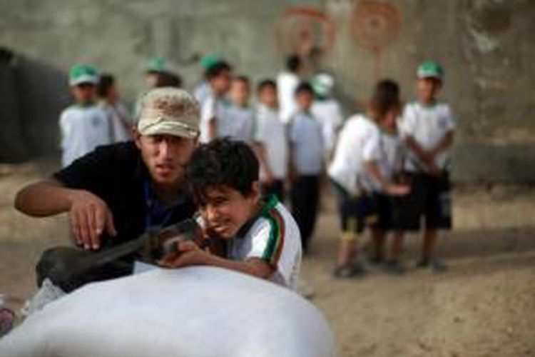 Anak laki-laki Palestina ambil bagian dalam latihan perang selama liburan musim panas yang diselenggarakan oleh Hamas di Kota Gaza, 10 Juni 2013.