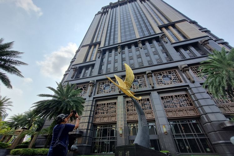 Seorang pengunjung sedang memotret patung golden crane di halaman Parkview Square, Singapura, Jumat (6/10/2023).