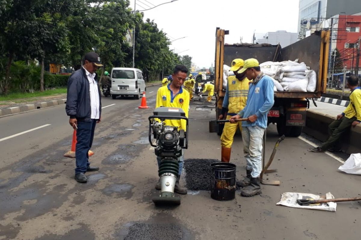 Petugas dari Suku Dinas Bina Marga Jakarta Pusat memperbaiki jalan rusak dan berlubang di Gunung Sahari, Jakarta Pusat, Rabu (30/1/2019).