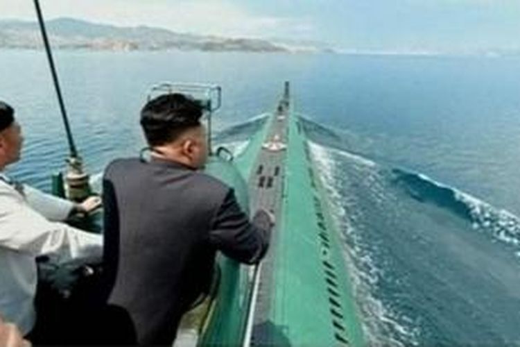 Dalam foto yang ditampilkan stasiun televisi pemerintah Korea Utara, terlihat Kim Jong Un berada di menara salah satu kapal selam AL Korea Utara bersama komandan kapal selam tersebut.