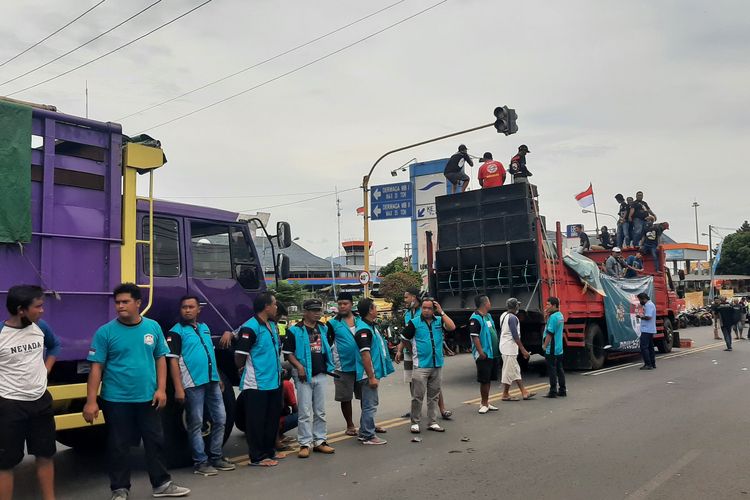 Ratusan truk milik sopir anggota Aliansi Komunitas Sopir Indonesia (Aksi) menutup akses keluar dan masuk Pelabuhan Ketapang, Kabupaten Banyuwangi, Jawa Timur, oleh pengemudinya, Senin (3/1/2021).