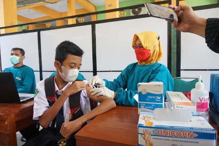 DIVAKSIN—Siswi SMPN 1 Geger Kabupaten Madiun, Jawa Timur disuntik vaksin covid-19. Vaksinasi anak di Kabupaten Madiun dipercepat agar pembelajaran tatap muka segera digelar di wilayah tersebut.